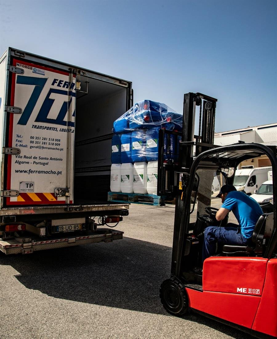 Forklift loading pallets into a truck at a warehouse