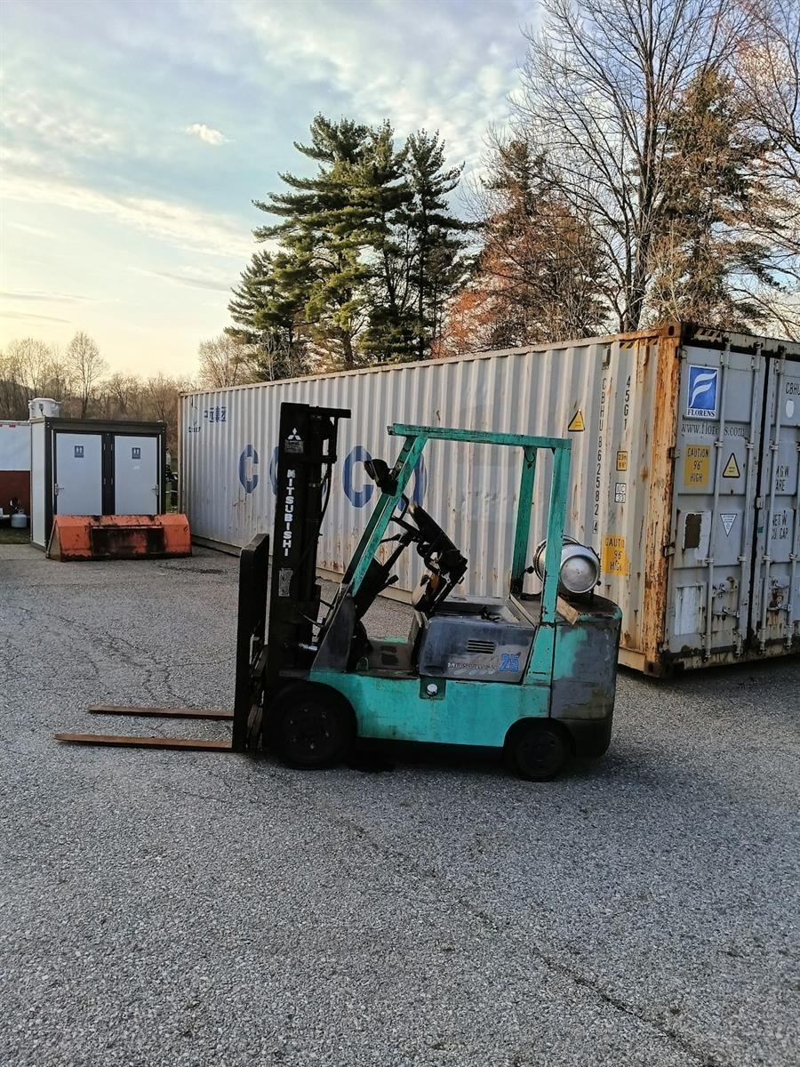 Industrial forklift in front of shipping containers
